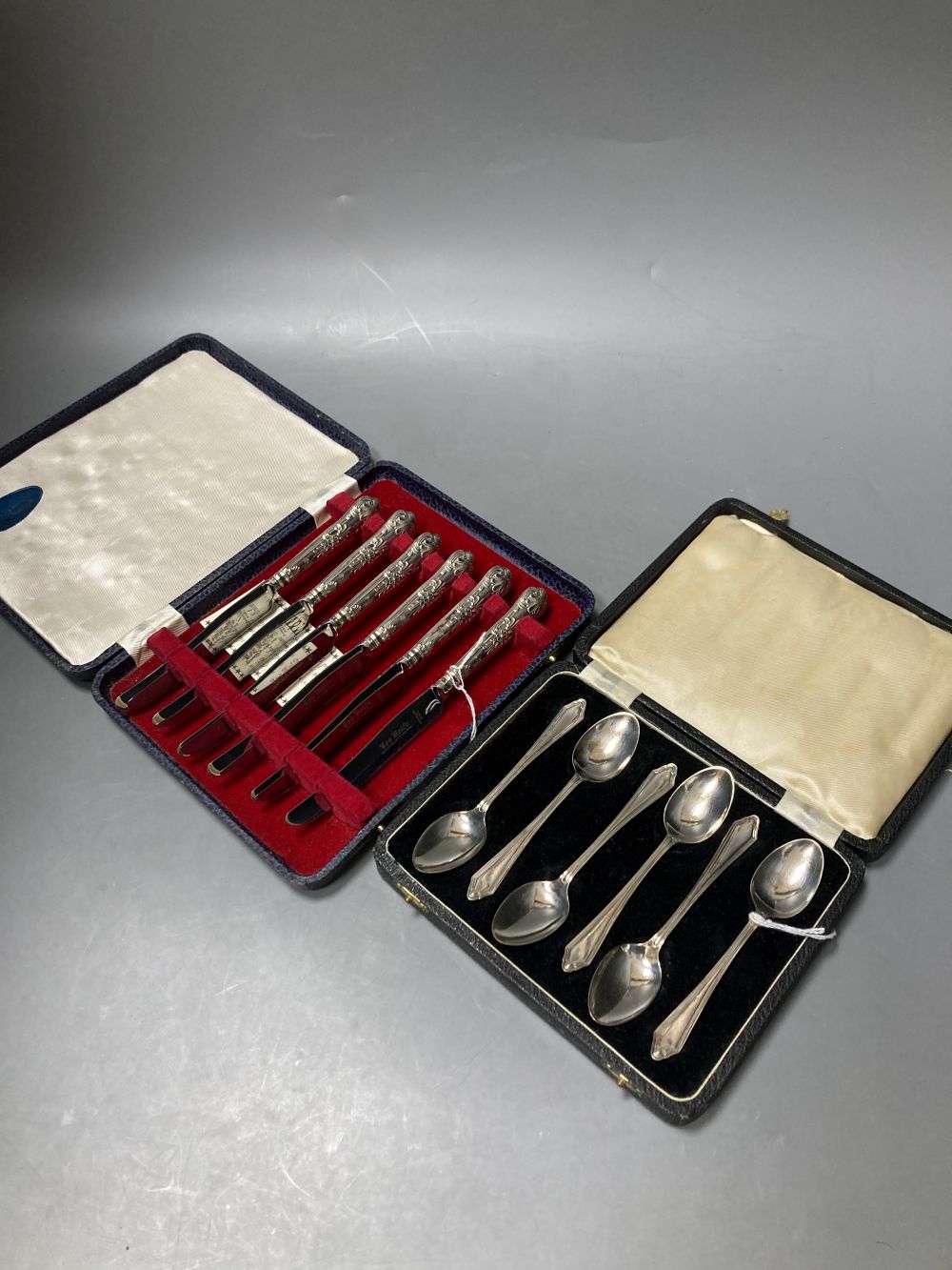 A cased set of six 1930s silver teaspoons and a cased set of six silver handled cake knives.